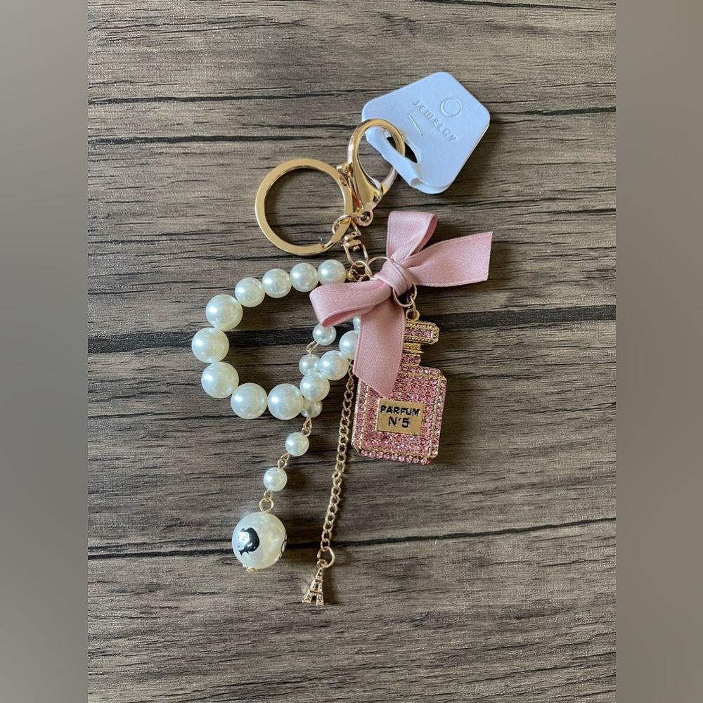 NWT: A parfum bottle with pink ribbon purse charm or keychain.